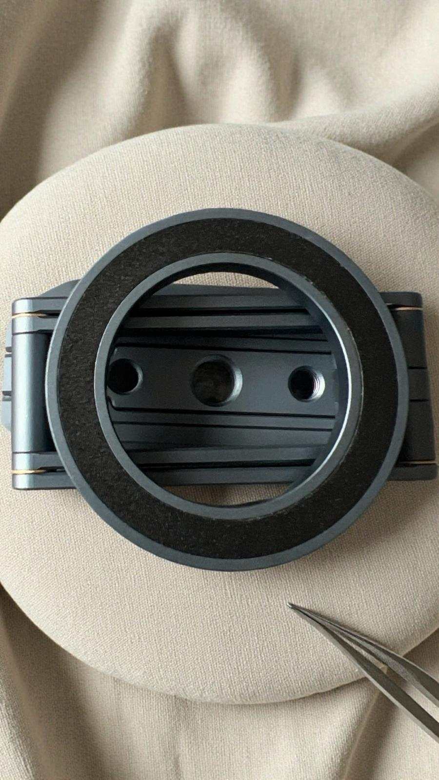 Close-up of a black metal ring on a beige fabric background